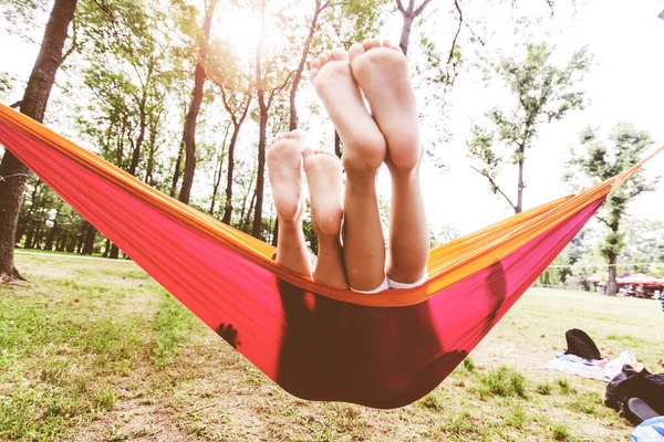 Çocuklar doğanın tadını çıkarıyorlar. Yaz günü hamakta dinleniyorlar..