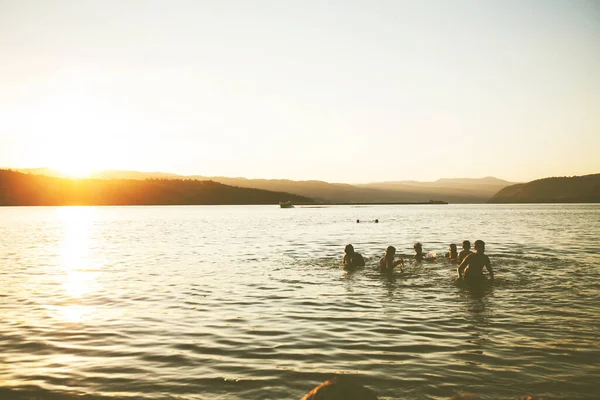 夏日的欢乐 朋友们在海滩上享受夕阳西下 在水里飞溅 — 图库照片