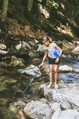 Küçük kız dağ deresinde iyi eğlenceler. Doğadaki yaz günü 