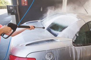 Otomobil yıkama istasyonunda basınçlı yıkama makinesiyle yıkama..