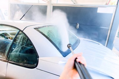 Otomobil yıkama istasyonunda basınçlı yıkama makinesiyle yıkama..