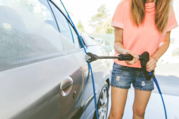 Pretty Woman Washing Her Car With High Pressure Washer At Self-Serve Car Wash