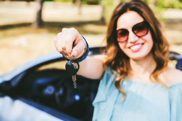 車のキーを示す笑顔の女性の肖像画 鍵に集中しろ 夏時間だ 自然背景 — ストック写真