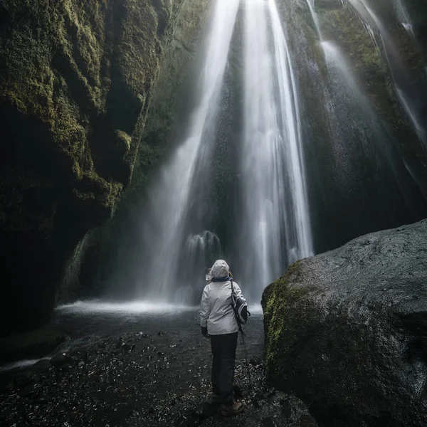 Mujer mirando la cascada de Gljufrabui dentro de una cueva en Icel — Foto de Stock