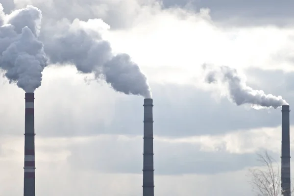 Smoking chimney against moody sky