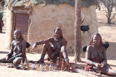NAMIBIA - 28 Kasım 2016, Himba kadınları köyde hediyelik eşya taşıyorlar