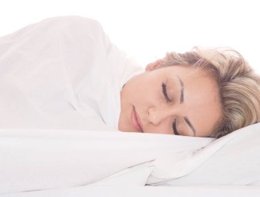 Genç ve güzel bir kadın yatakta uyuyor.