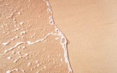 Kumlu sahilde şeffaf yumuşak dalgalar