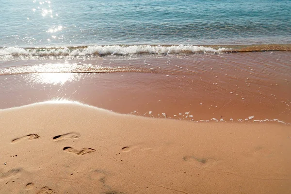 Voetafdrukken Een Zandstrand Bij Zonsopgang — Stockfoto