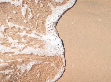 Kumlu sahilde şeffaf yumuşak dalgalar