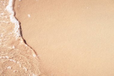 Kumlu sahilde şeffaf yumuşak dalgalar