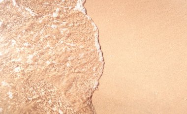 Kumlu sahilde yumuşak dalgalar