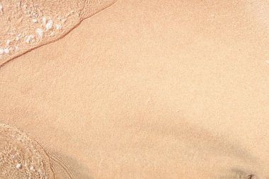 Kumlu sahilde şeffaf yumuşak dalgalar