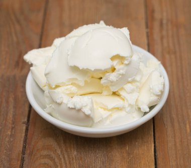 Mascarpone peyniri ahşap arka planda beyaz kasede