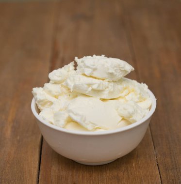 Mascarpone peyniri ahşap arka planda beyaz kasede