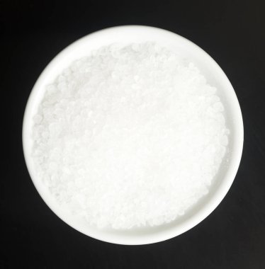 Siyah arka planda bir kasede deniz tuzu