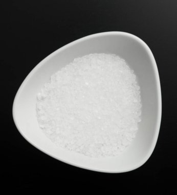 Siyah arka planda bir kasede tuz.