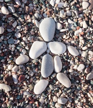 Kumsaldaki çakıl taşı adam