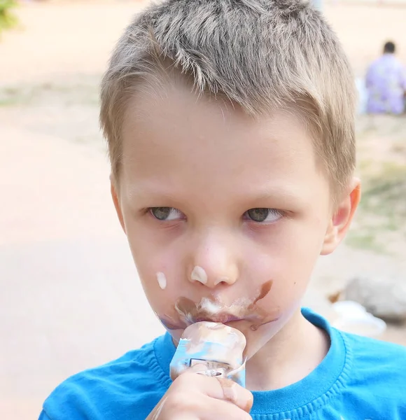 汚れた顔でアイスクリームを食べる男の子 — ストック写真