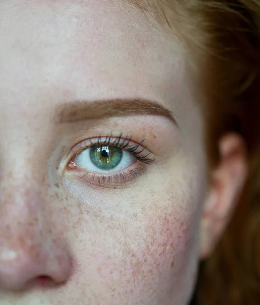 半分の女性の顔で緑の目とそばかす — ストック写真