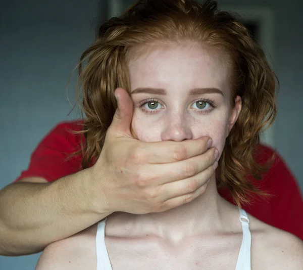 Man covering mouth of young woman