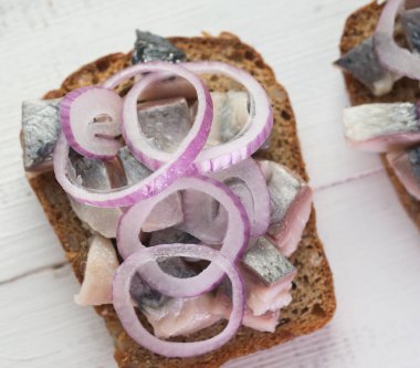 Tuzlu ringa balığı ve kırmızı soğanlı sandviç.