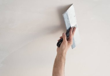 İnşaatçının eli tavanı yeniliyor.