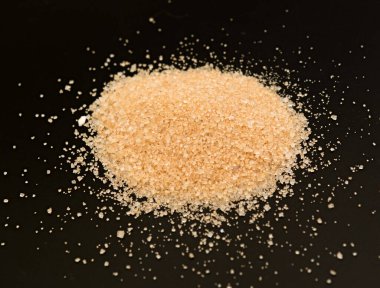 Siyah arka planda kahverengi kamış şekeri yığını