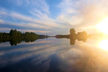 Gölün üzerinde parlak, güzel gün batımı