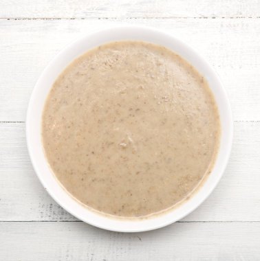 Tahta bir masada mantar kremalı çorba.