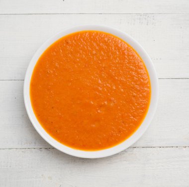 Tahta bir masada domates kremalı çorba.