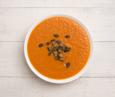 Tahta bir masada domates kremalı çorba.