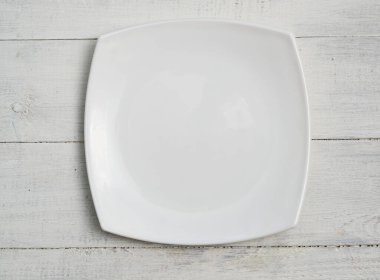 Ahşap bir masada kare bir tabak.