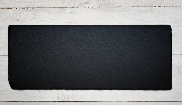 木製の背景に黒いプレートをスレート — ストック写真