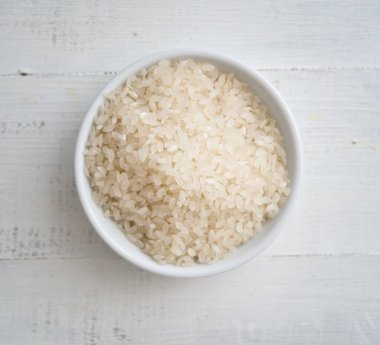 Tahta arka planda bir kasede pirinç