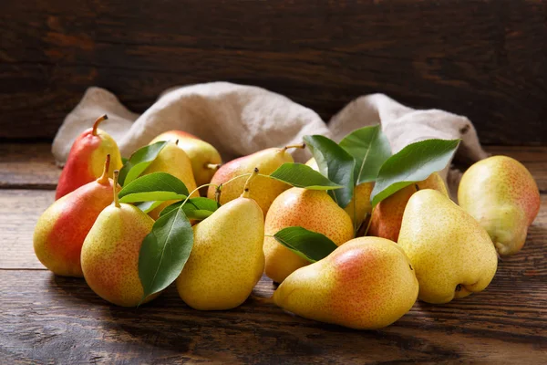 fresh pears with leaves on wooden table