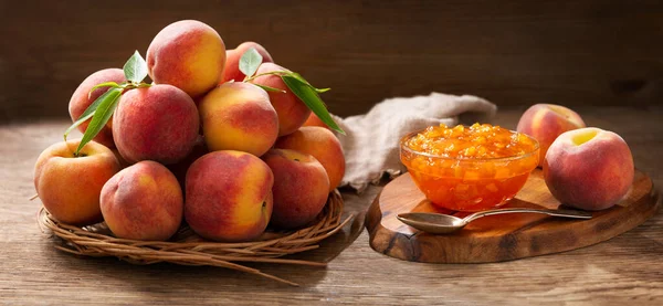 bowl of peach jam and fresh fruits on a wooden table