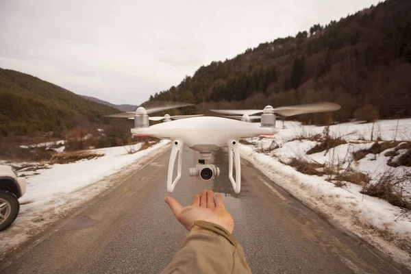 winter landscape with drone over male hand