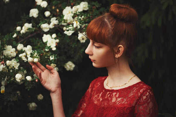Portrait of beautiful red haired girl in park