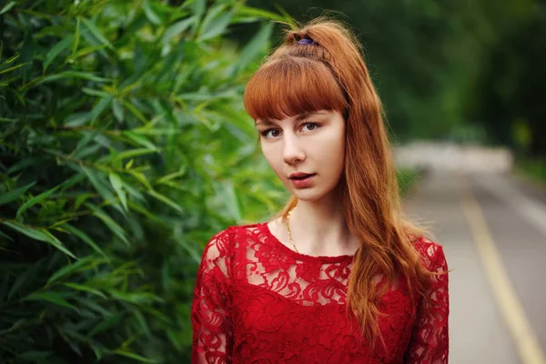 Beautiful red haired girl in park — Stock Photo, Image