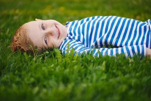 Маленький мальчик лежит на траве — стоковое фото