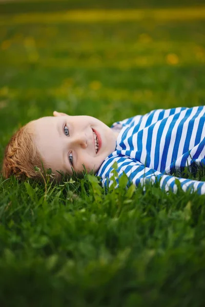 Malý chlapec ležící na trávě — Stock fotografie