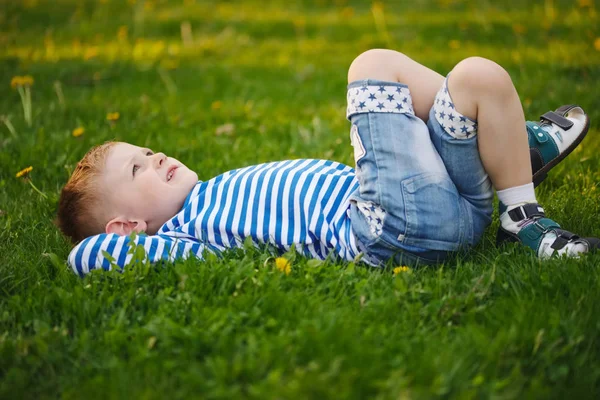 Kleiner Junge liegt im Gras — Stockfoto