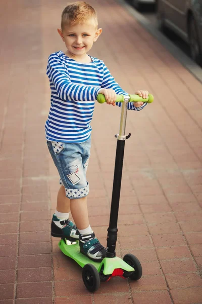 Pequeño niño feliz montando en scooter —  Fotos de Stock