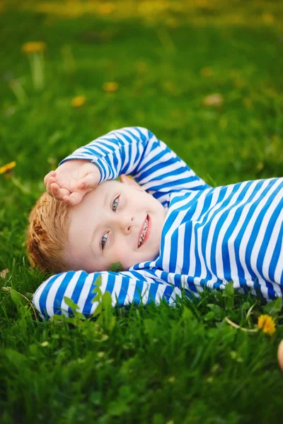 Mały chłopiec leżący na trawie — Zdjęcie stockowe