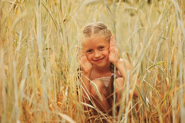 Jong meisje in het geel veld — Stockfoto