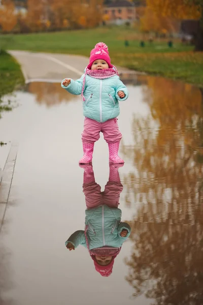 Little girl with rubber boots in puddle — Stock Photo, Image