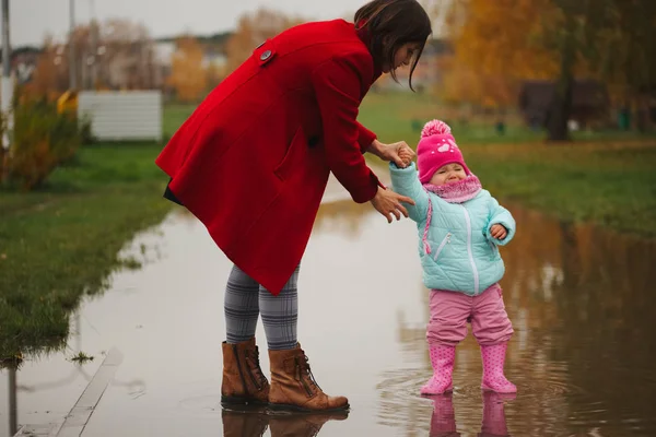 Petite fille avec des bottes en caoutchouc dans la flaque — Photo