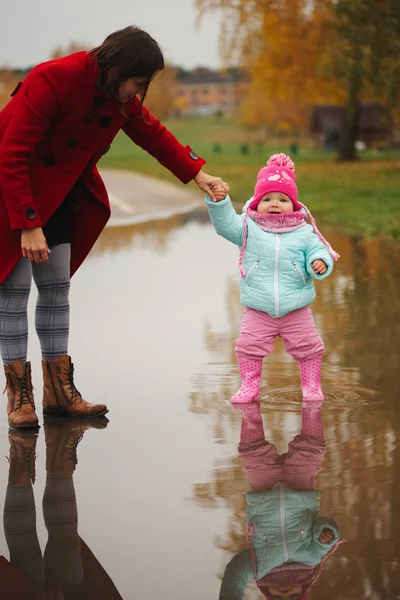 Petite fille avec des bottes en caoutchouc dans la flaque — Photo