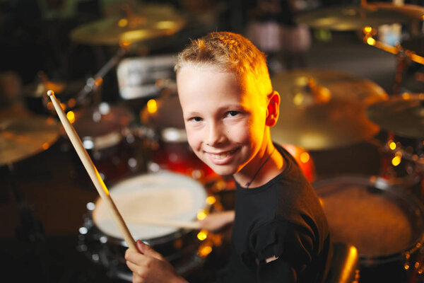 boy plays drums in recording studio